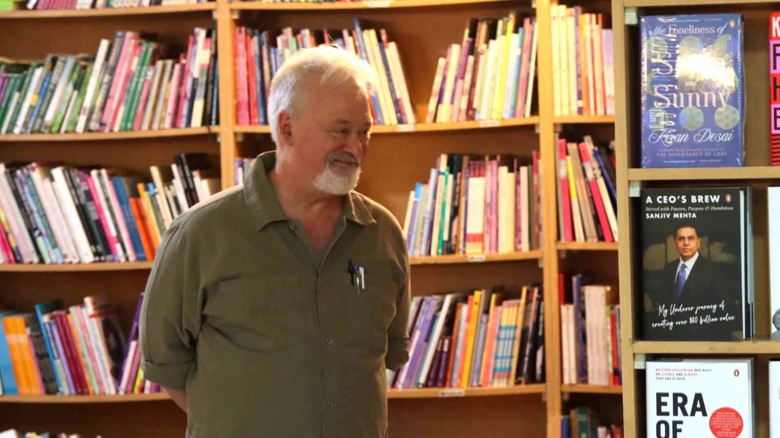 Dr. David P. Smith smiling among the bookshelves of a bookstore