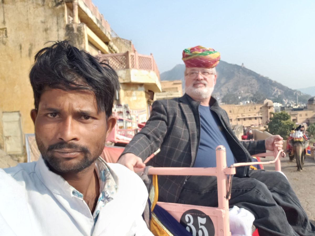 Dr. Smith riding an elephant through a town in northern India, with a local guide